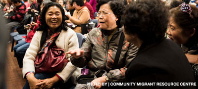 Image of four Asian-Australian women talking at crowed community event